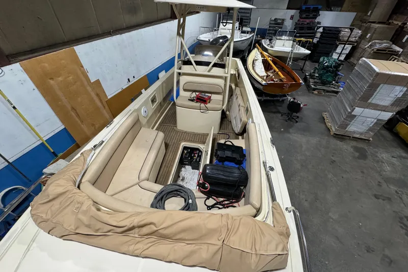 Slide: The Image of 2020 Vanquish Runabout boat in storage, featuring beige seating and equipment. - 13
