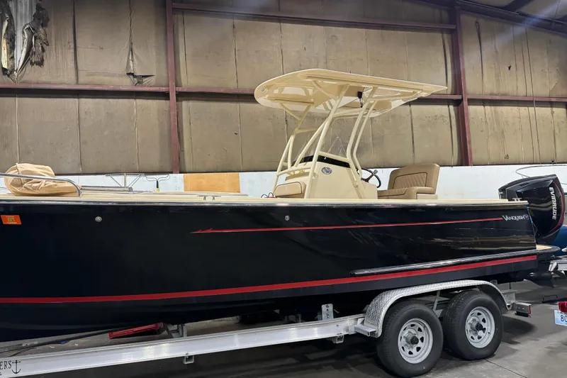 Slide: The Image of 2020 Vanquish Runabout boat in a warehouse, black with red trim, on a trailer. - 4