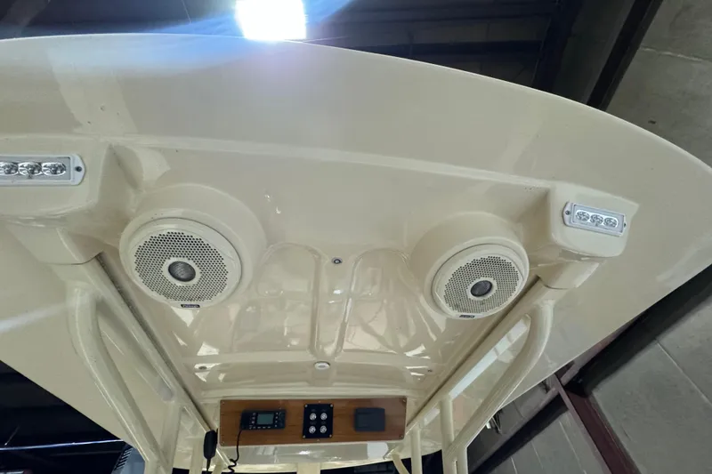 Slide: The Image of 2020 Vanquish Runabout boat roof with speakers and LED lights in a garage setting. - 8