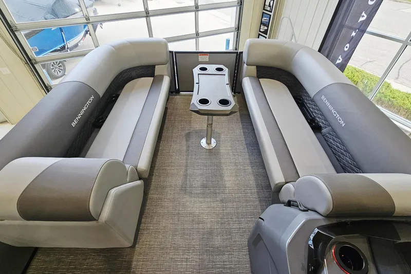 Slide: The Image of 2024 Bennington 22 S Swingback boat interior with gray seating and central table. - 12