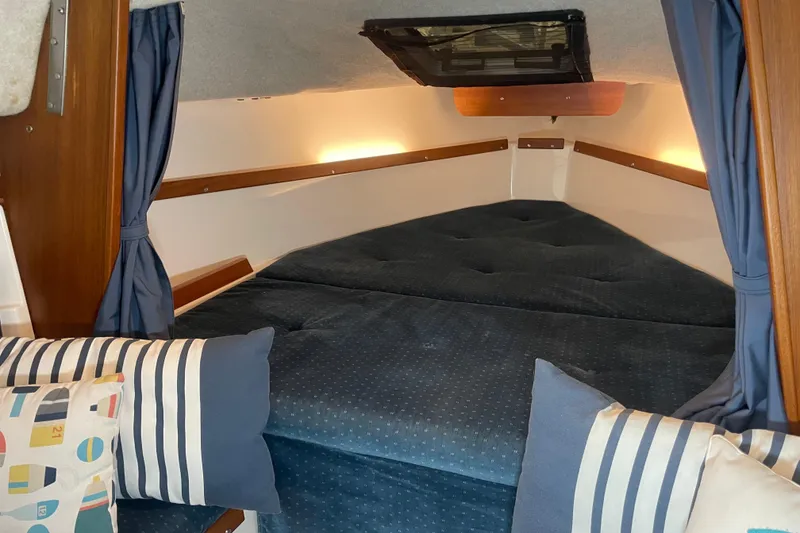 Slide: The Image of Cozy cabin interior of a 2001 Precision 23 sailboat with blue cushions and striped pillows. - 12