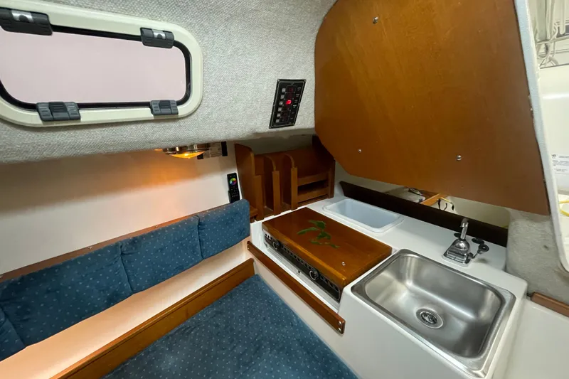 Slide: The Image of Interior of a 2001 Precision 23 sailboat with kitchenette and seating area. - 15