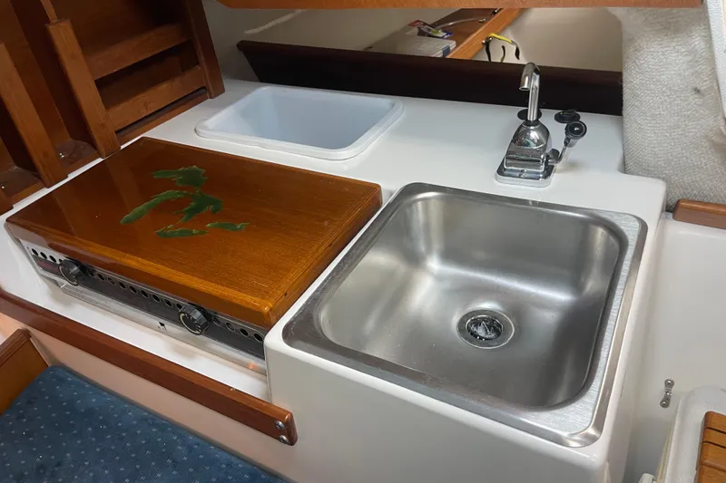 Slide: The Image of Compact kitchen area in a 2001 Precision 23 boat, featuring a sink and stove. - 16
