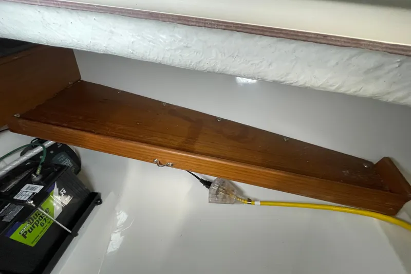 Slide: The Image of Wooden shelf and battery setup in a 2001 Precision 23 boat interior. - 24