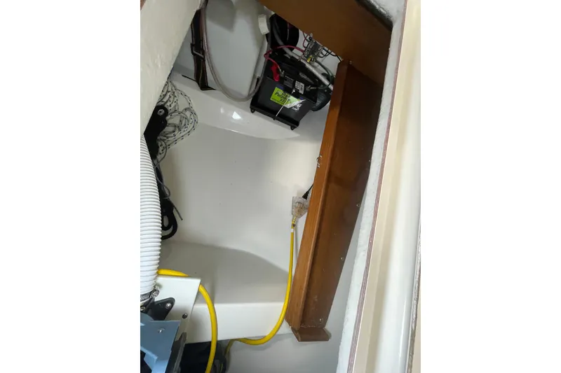 Slide: The Image of Interior view of a 2001 Precision 23 sailboat, showcasing wiring and battery compartment. - 28