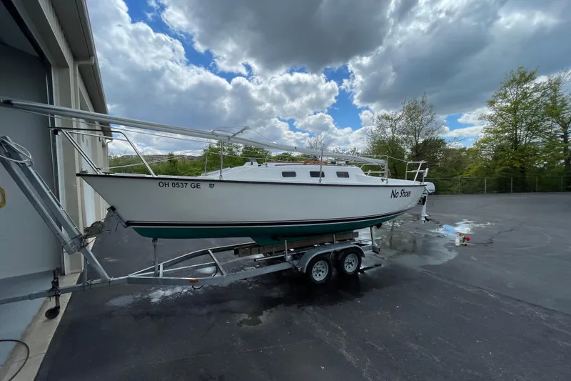 Slide: The Image of 2001 Precision 23 sailboat on trailer under cloudy sky, parked near building. - 32