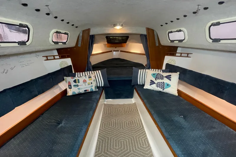 Slide: The Image of Interior of a 2001 Precision 23 sailboat with cozy seating and decorative pillows. - 9