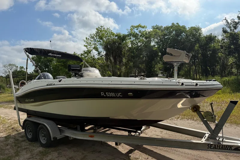 Slide: The Image of 2016 Hurricane SunDeck Sport 203 OB boat on trailer, parked outdoors. - 1