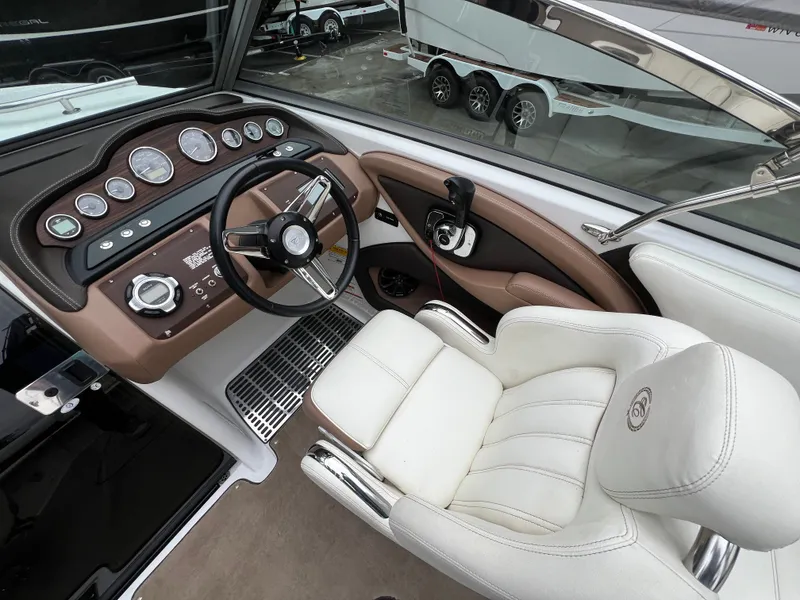Slide: The Image of Interior of a 2014 Cobalt 243 boat with steering console and leather seat. - 14