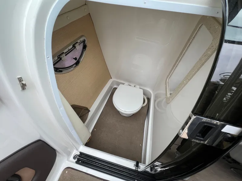 Slide: The Image of Interior of a 2014 Cobalt 243 yacht featuring a compact toilet. - 16