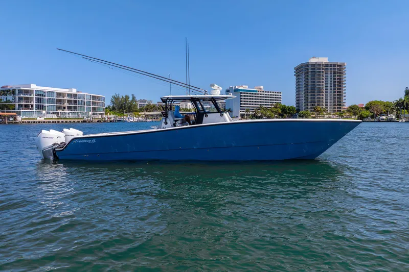 Slide: The Image of 2019 Freeman 42LR boat on water, cityscape background, clear blue sky. - 13