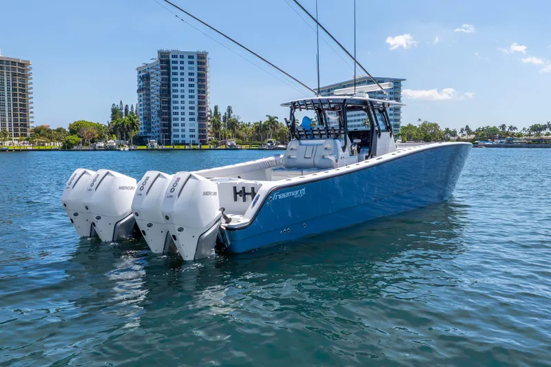 Slide: The Image of 2019 Freeman 42LR boat with triple Mercury engines on a sunny waterfront. - 15