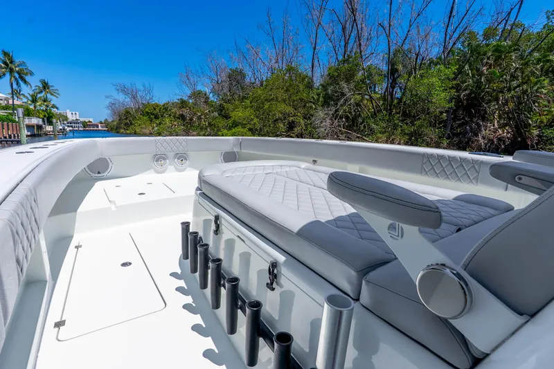Slide: The Image of Luxurious 2019 Freeman 42LR boat interior with plush seating and rod holders, surrounded by lush greenery. - 27