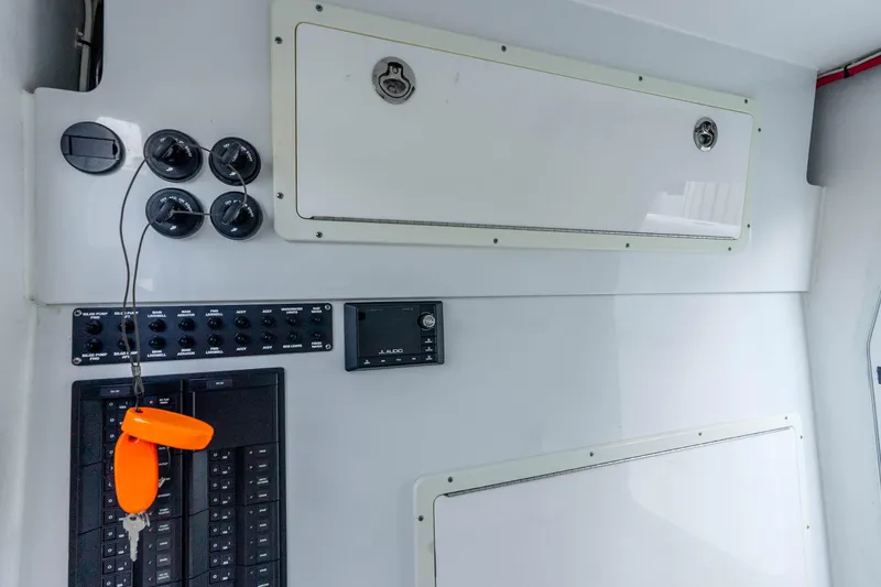 Slide: The Image of Control panel of a 2019 Freeman 42LR boat with switches and storage compartments. - 56