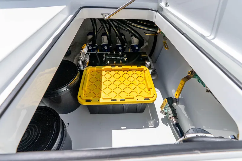 Slide: The Image of Storage compartment of a 2019 Freeman 42LR boat, featuring equipment and yellow container. - 59
