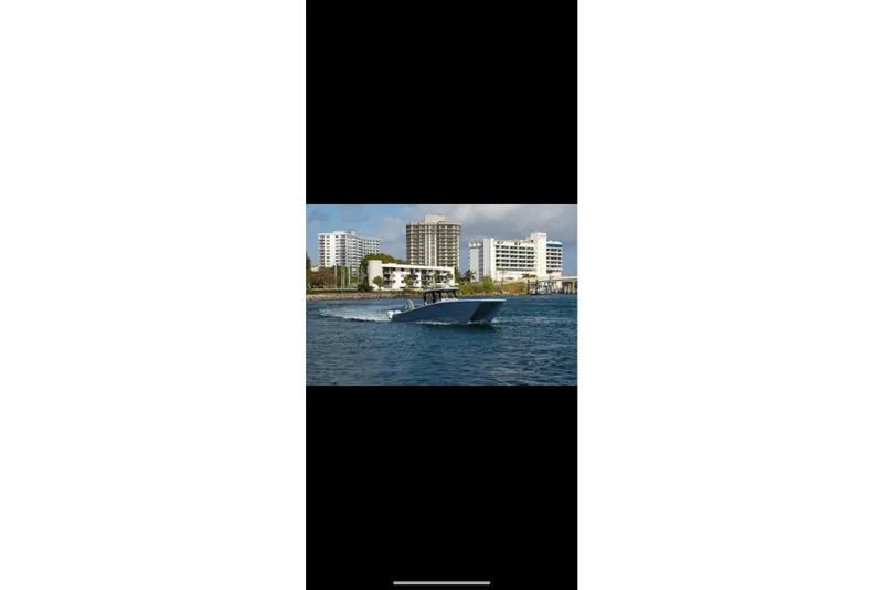Slide: The Image of A 2019 Freeman 42LR boat cruising on open blue water with four powerful engines. - 6