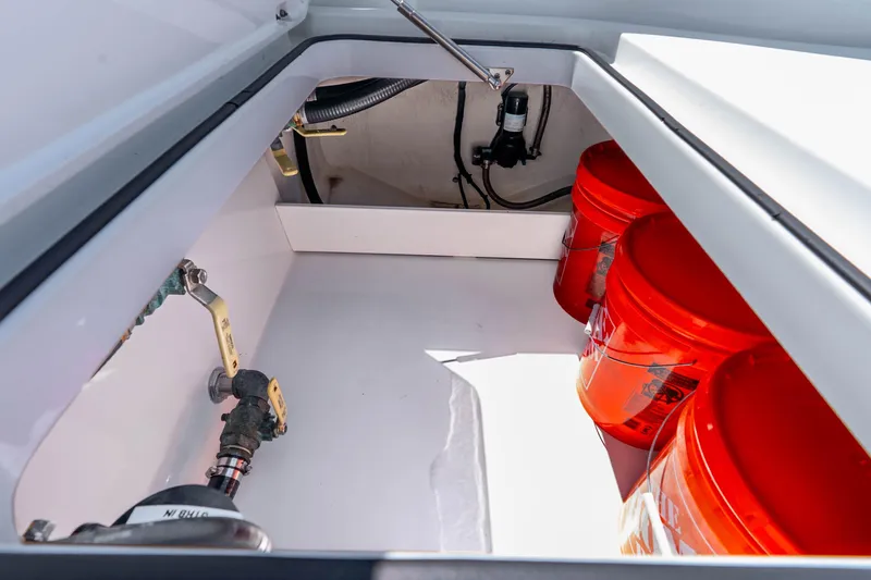 Slide: The Image of Storage compartment of 2019 Freeman 42LR boat with orange buckets and plumbing components. - 60