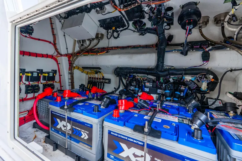 Slide: The Image of Battery compartment of a 2019 Freeman 42LR boat, featuring multiple AGM batteries and wiring. - 64
