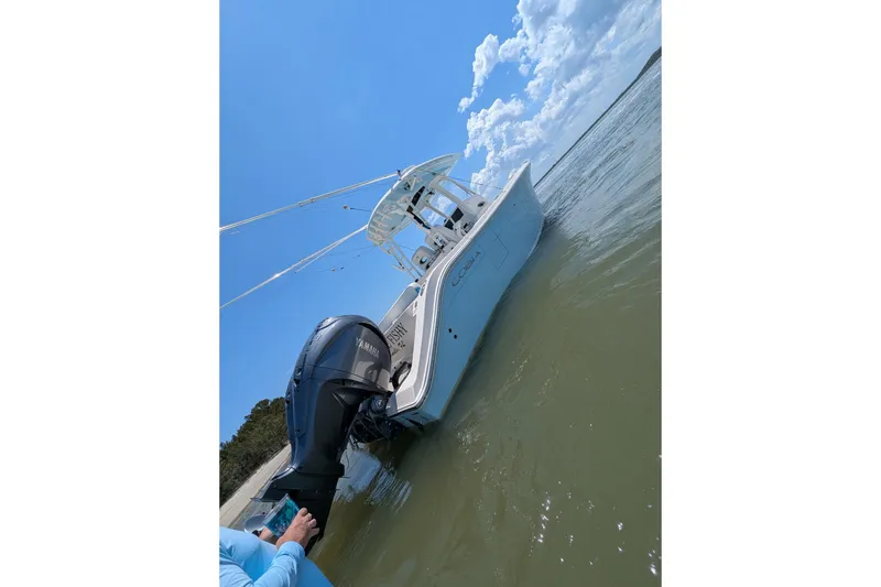 Slide: The Image of 2023 Cobia 301 Center Console boat on water with Yamaha outboard motor. - 27