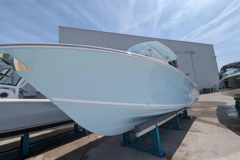 Slide: The Image of 2023 Cobia 301 Center Console boat displayed outdoors on a stand. - 28