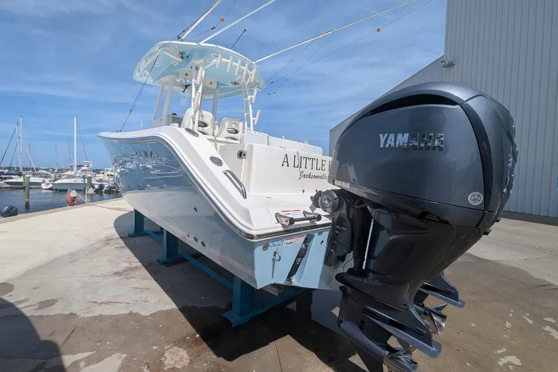 Slide: The Image of 2023 Cobia 301 Center Console boat with Yamaha engines at a marina dock. - 29