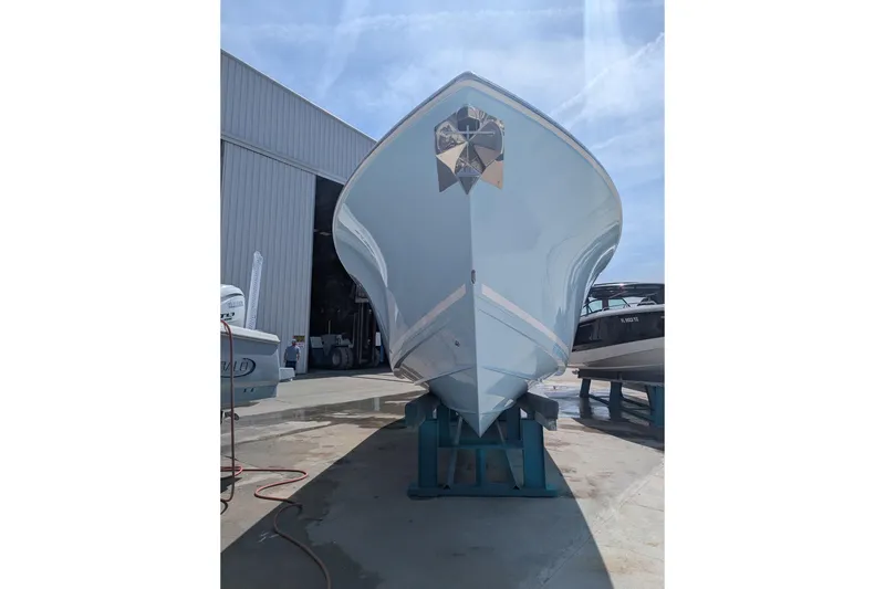 Slide: The Image of 2023 Cobia 301 Center Console boat on stands outside a warehouse. - 31