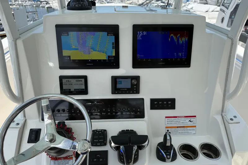 Slide: The Image of 2023 Cobia 301 Center Console dashboard with Garmin displays and steering wheel. - 33