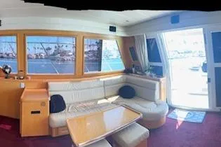 Slide: The Image of Interior of a 1999 McKinna 57 Pilothouse yacht with spacious seating and large windows. - 11