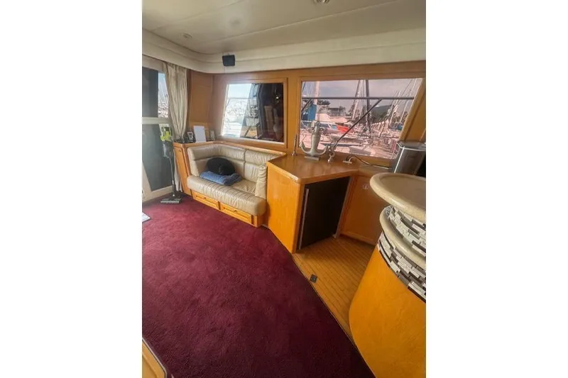 Slide: The Image of Interior of 1999 McKinna 57 Pilothouse yacht with plush seating and red carpet. - 14