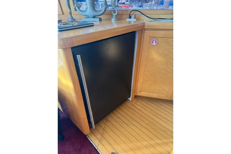 Slide: The Image of Built-in black refrigerator on 1999 McKinna 57 Pilothouse yacht with wooden cabinetry. - 15