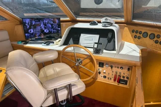 Slide: The Image of Pilothouse interior of 1999 McKinna 57, featuring helm, captain's chair, and navigation equipment. - 23