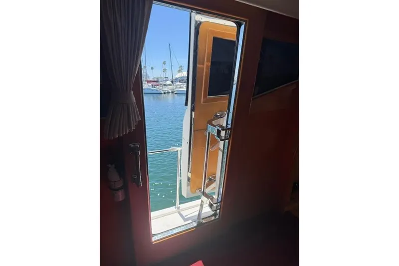 Slide: The Image of Interior view from a 1999 McKinna 57 Pilothouse yacht, overlooking a marina. - 25
