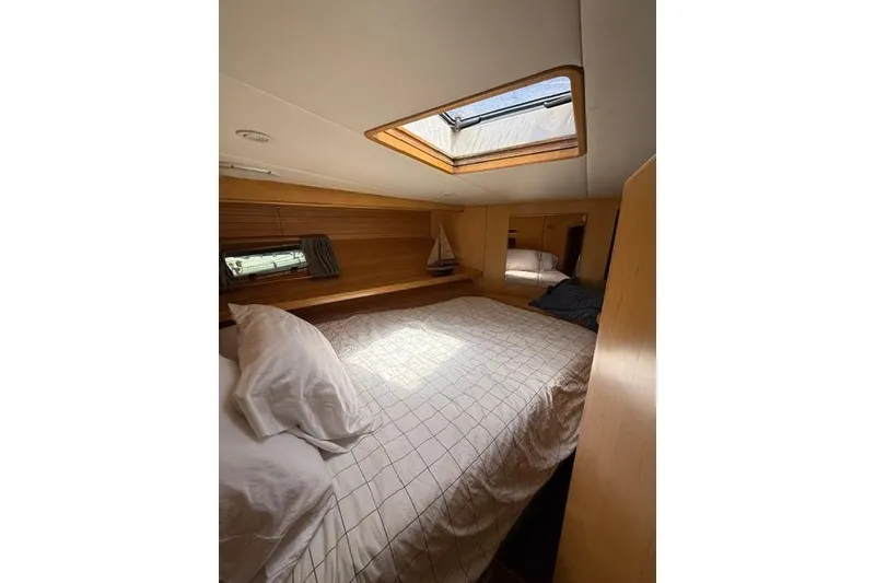 Slide: The Image of Cozy bedroom in 1999 McKinna 57 Pilothouse yacht with skylight and wooden accents. - 27