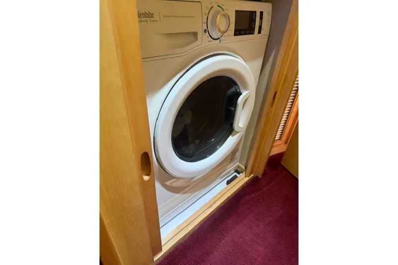 Slide: The Image of Built-in washing machine on a 1999 McKinna 57 Pilothouse yacht, with wooden cabinetry. - 31