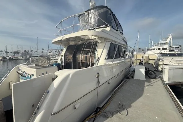 Slide: The Image of 1999 McKinna 57 Pilothouse yacht docked at marina under clear sky. - 5