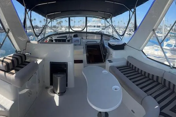 Slide: The Image of 1999 McKinna 57 Pilothouse yacht interior with seating and helm, docked at marina. - 9