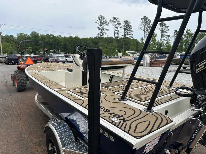 Slide: The Image of 2026 Xpress Skiff boat parked on trailer outdoors. - 4