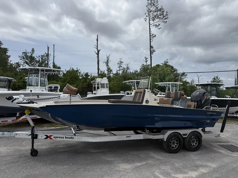 The Image of 2026 Xpress X23B Bay Lounge boat on trailer, cloudy sky. - 1