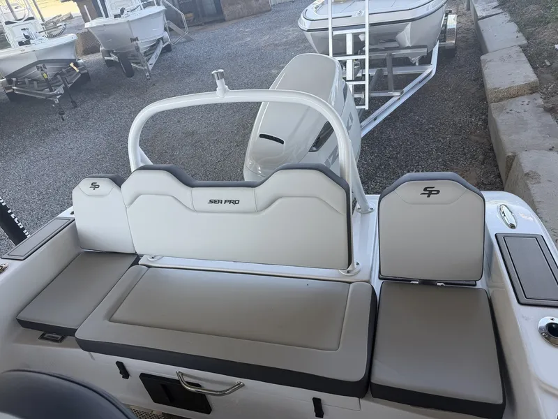 Slide: The Image of 2026 Sea Pro 245FLX R boat rear seating in a marina. - 19