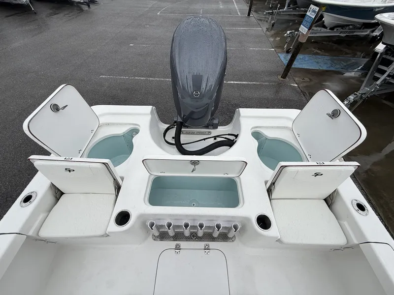 Slide: The Image of 2026 Sea Pro 230 Bay boat with open storage compartments and motor. - 12