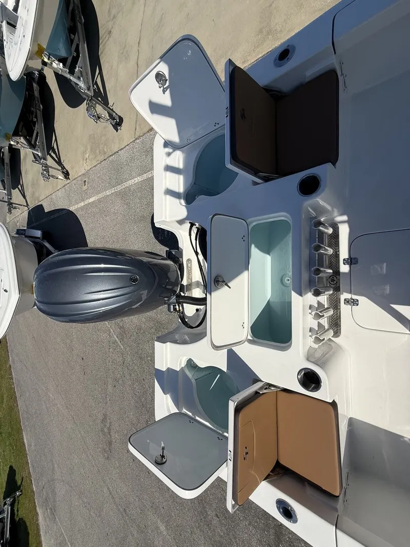 Slide: The Image of 2026 Sea Pro 230 Bay boat with open storage compartments and motor. - 14