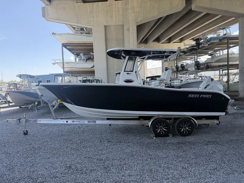 The Image of 2026 Sea Pro 242 DLX boat on trailer under bridge. - 1