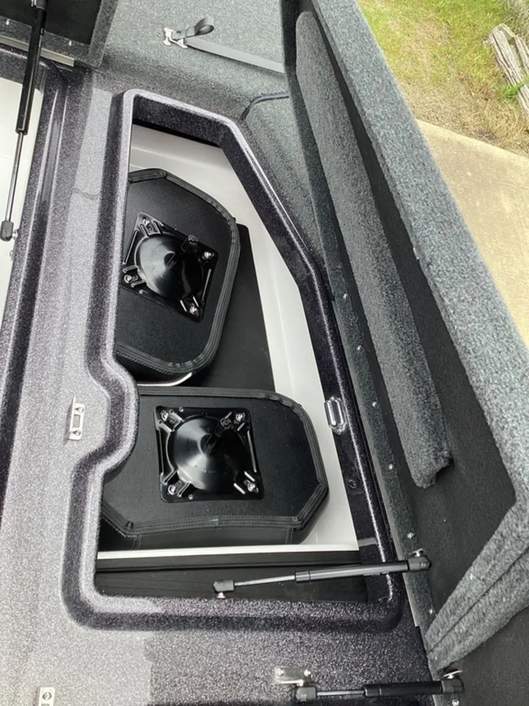 Slide: The Image of Skeeter ZXE21 2026 boat storage compartment with two black speakers. - 46