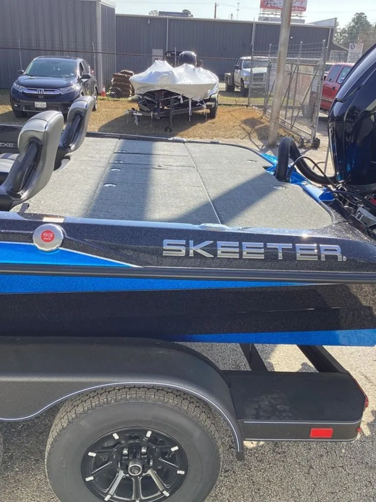 Slide: The Image of 2026 Skeeter ZXE21 boat on trailer, blue and black, parked outdoors. - 14