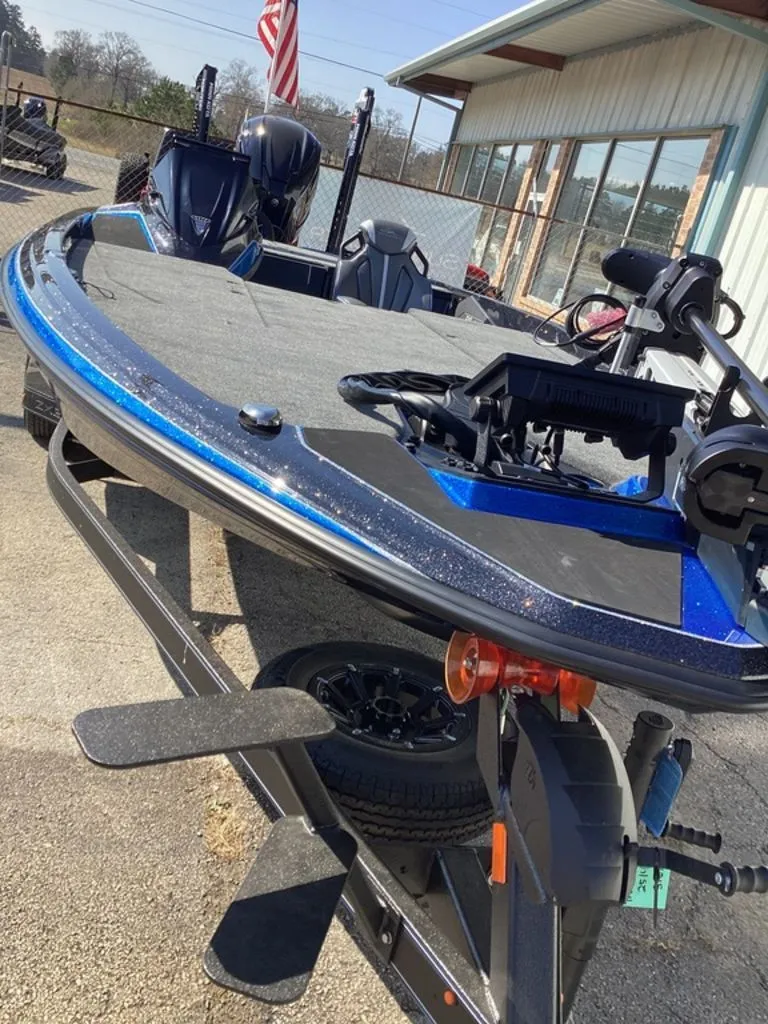 Slide: The Image of Skeeter ZXE21 2026 boat on trailer, blue and black, parked outdoors. - 20