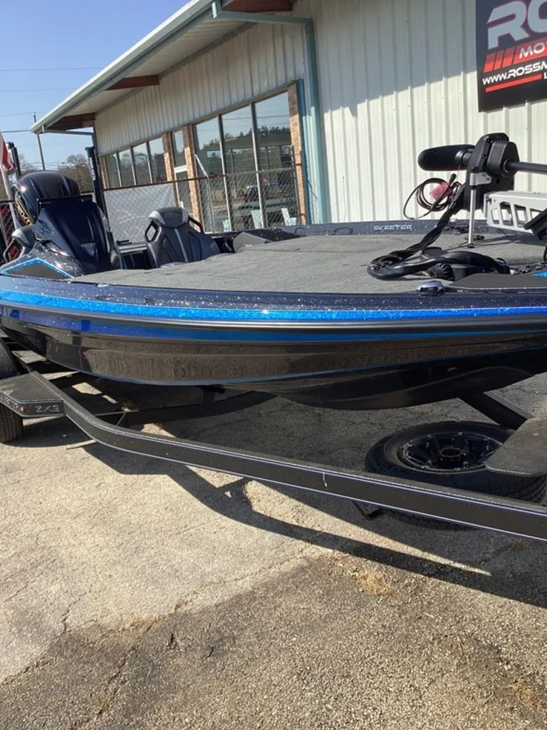 Slide: The Image of 2026 Skeeter ZXE21 boat on trailer outside building. - 21