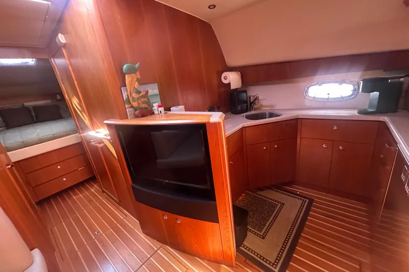 Slide: The Image of Interior of 2011 Tiara Yachts 4300 Open, featuring a cozy kitchen and sleeping area. - 6