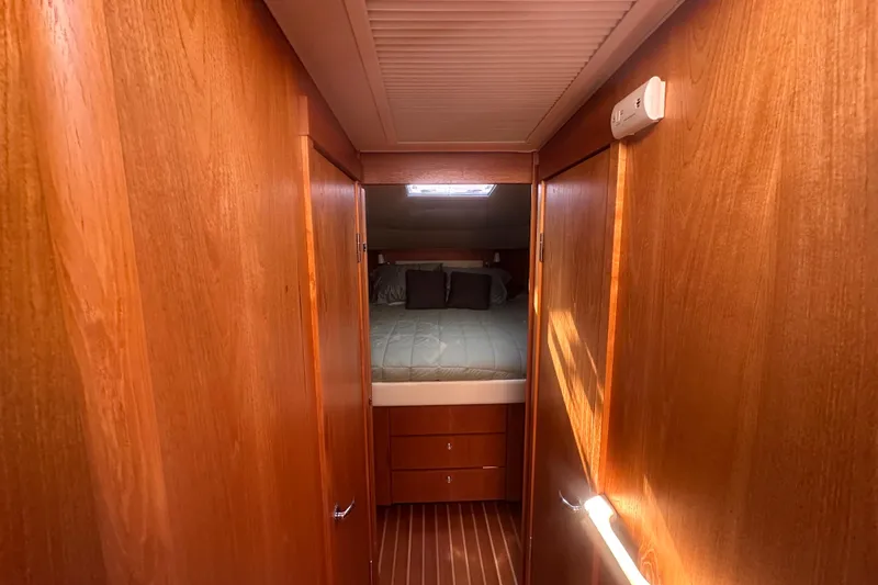 Slide: The Image of Interior cabin of 2011 Tiara Yachts 4300 Open, featuring wood paneling and a cozy bed. - 8