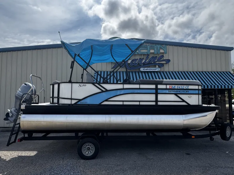 Slide: The Image of 2025 Bennington S20 pontoon boat parked in front of a building. - 3