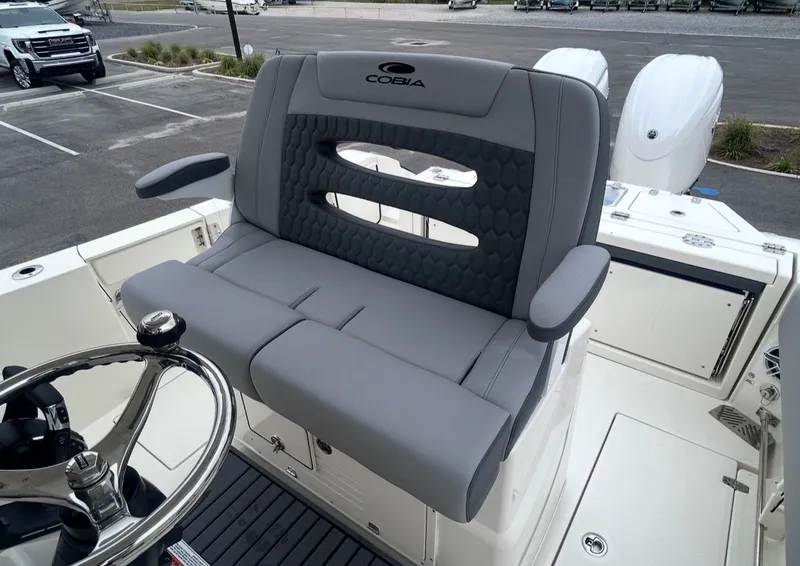 Slide: The Image of 2026 Cobia 245CC boat with gray seating and steering wheel. - 13